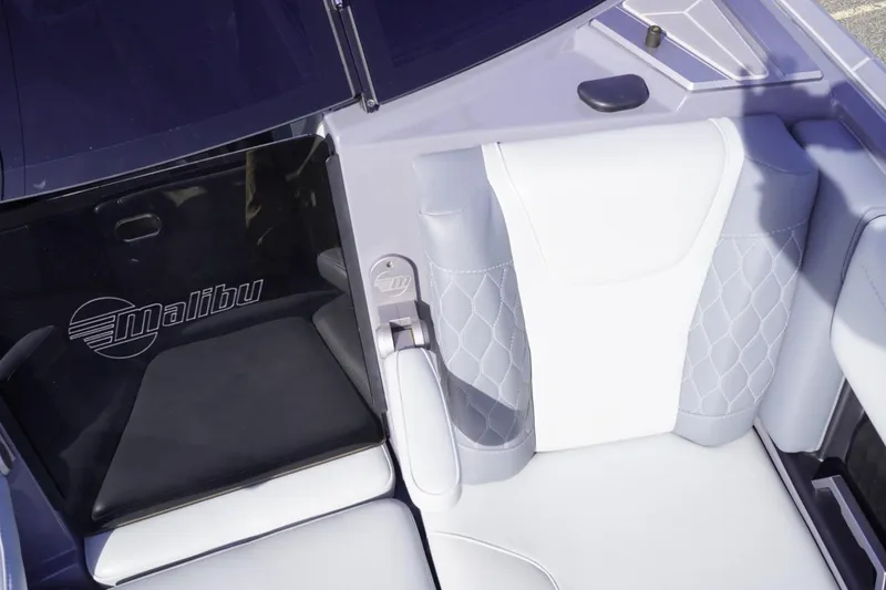 Slide: The Image of 2023 Malibu M220 boat interior with white and gray seating, featuring logo detail. - 44