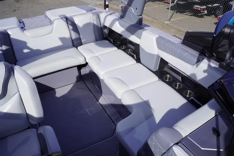 Slide: The Image of 2023 Malibu M220 boat interior with luxurious white seating and cup holders. - 49
