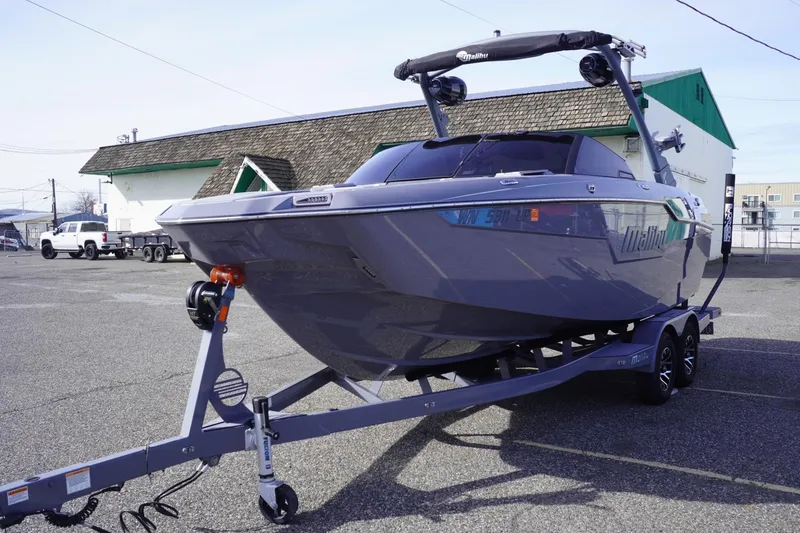 Slide: The Image of 2023 Malibu M220 boat on trailer in parking lot, side view. - 5