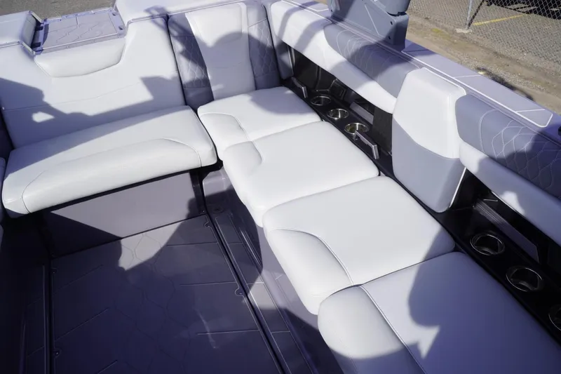 Slide: The Image of 2023 Malibu M220 boat interior with white seating and cup holders. - 50