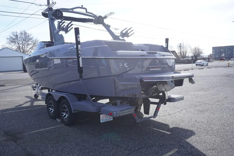 Slide: The Image of 2023 Malibu M220 boat on trailer in parking lot, rear view. - 9