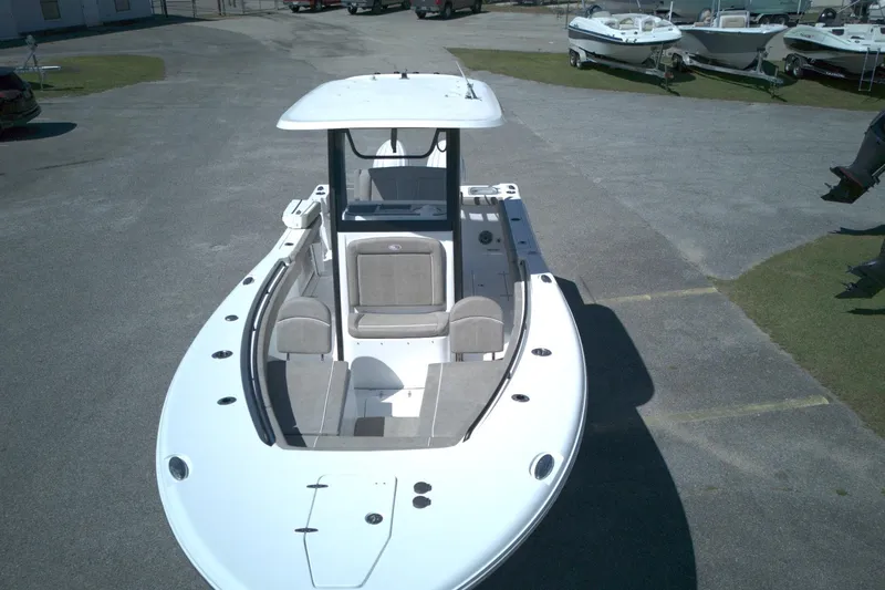 Slide: The Image of 2026 Sea Hunt Gamefish 25 boat, aerial view, parked on pavement with other boats nearby. - 2