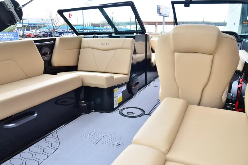 Slide: The Image of 2023 MasterCraft NXT24 boat interior with beige seating and modern design. - 14