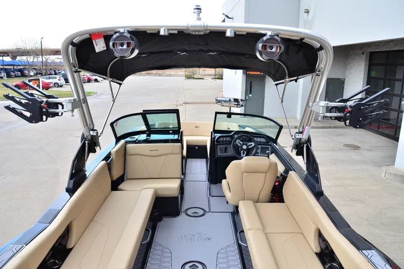 Slide: The Image of 2023 MasterCraft NXT24 boat interior with beige seating and modern dashboard. - 17