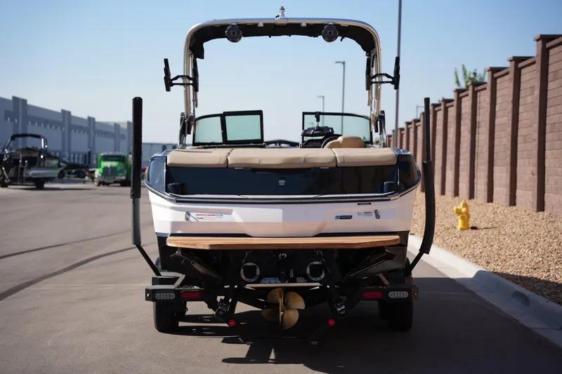 Slide: The Image of 2023 MasterCraft NXT24 boat rear view on a sunny day, parked on a street. - 3