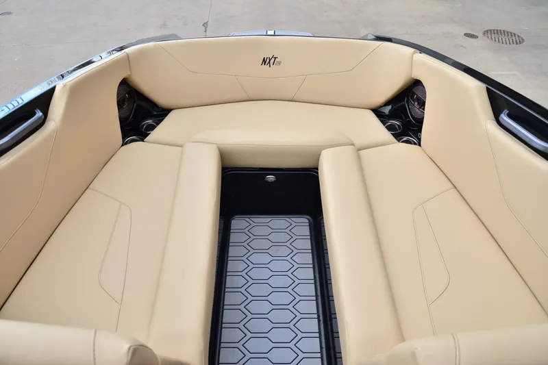 Slide: The Image of 2023 MasterCraft NXT24 boat interior with beige seating and hexagonal floor design. - 9