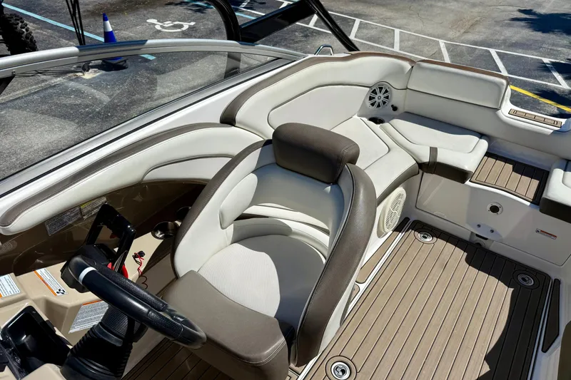 Slide: The Image of 2013 Yamaha Boats 242 Limited S interior with beige seating and steering wheel. - 12