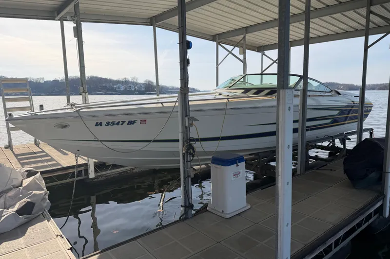Slide: The Image of 2001 Formula 312 FASTech boat docked under a covered marina on a calm lake. - 11