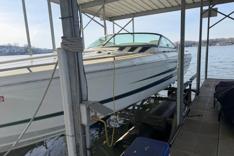 Slide: The Image of 2001 Formula 312 FASTech boat docked on a lift by the water. - 12