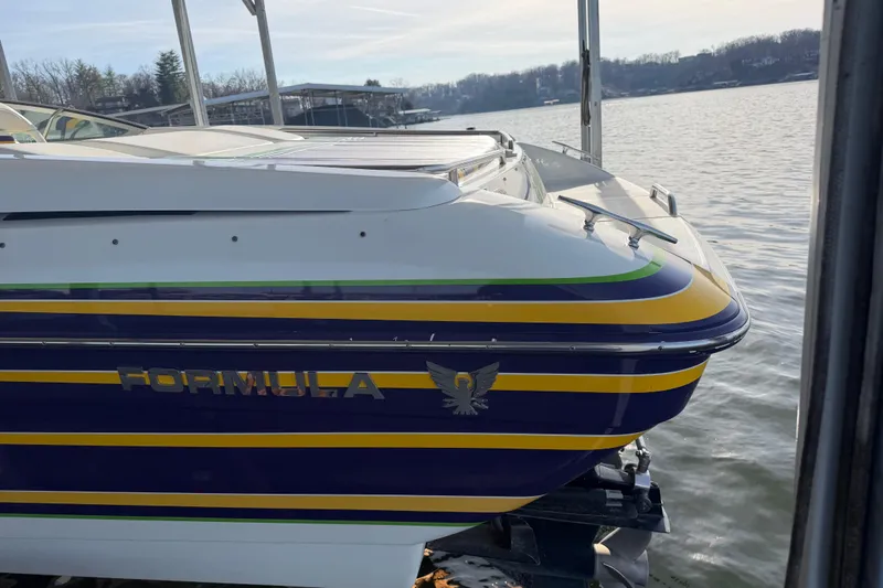 Slide: The Image of 2001 Formula 312 FASTech boat docked by the water, featuring vibrant stripes. - 14