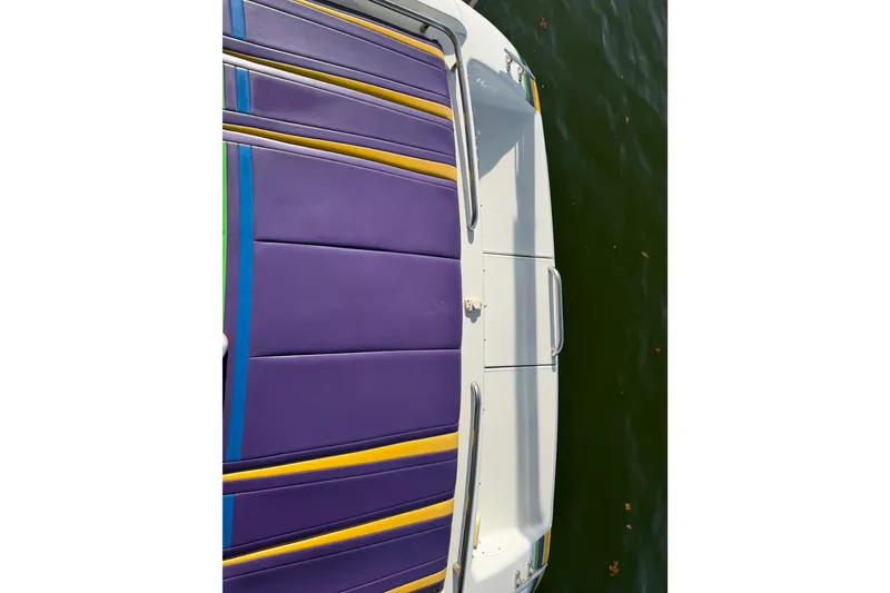 Slide: The Image of 2001 Formula 312 FASTech boat with vibrant purple and yellow seating, docked on water. - 16