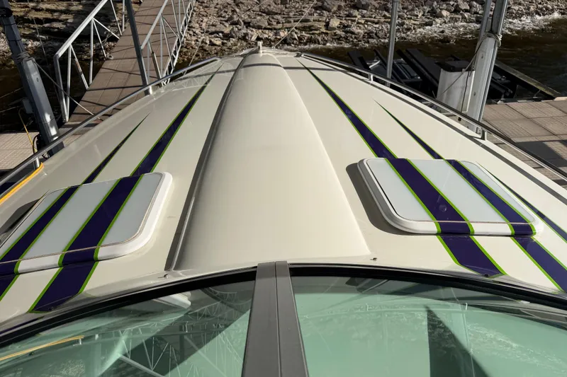 Slide: The Image of 2001 Formula 312 FASTech boat with sleek design and vibrant stripes docked by the water. - 28