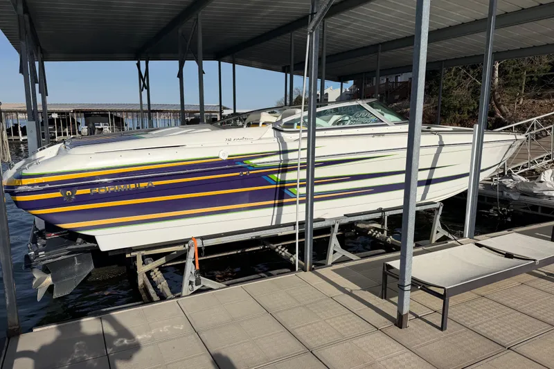 Slide: The Image of 2001 Formula 312 FASTech boat docked, featuring vibrant stripes and sleek design. - 3