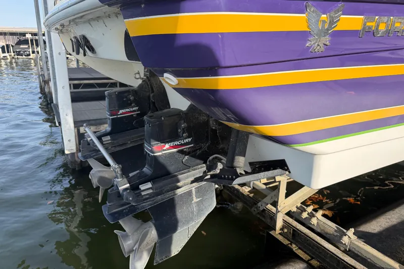 Slide: The Image of 2001 Formula 312 FASTech boat with dual Mercury engines, docked on a sunny day. - 5