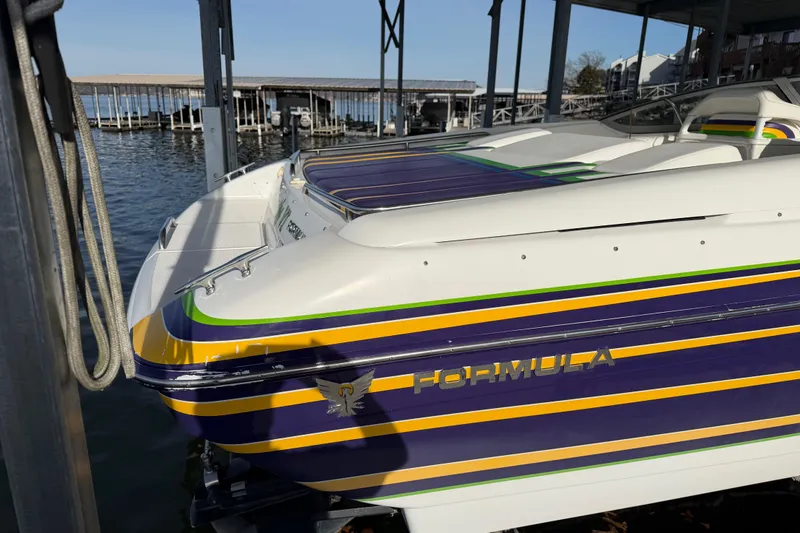 Slide: The Image of 2001 Formula 312 FASTech boat docked, featuring vibrant stripes and sleek design. - 6