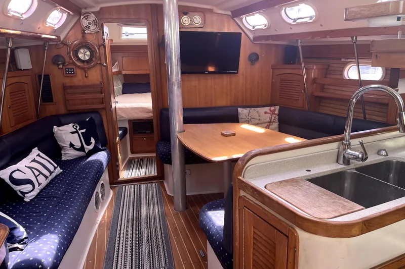 Slide: The Image of Interior of a 2006 Catalina 400 MkII sailboat with cozy seating and kitchen area. - 25