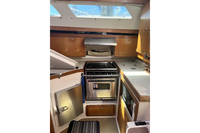 Slide: The Image of 2006 Catalina 400 MkII yacht kitchen with stove, oven, and wooden cabinetry. - 26