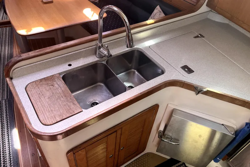 Slide: The Image of Galley kitchen in 2006 Catalina 400 MkII sailboat with double sink and wooden cabinetry. - 31