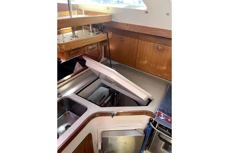 Slide: The Image of Interior of 2006 Catalina 400 MkII yacht kitchen with wooden cabinets and open fridge. - 33