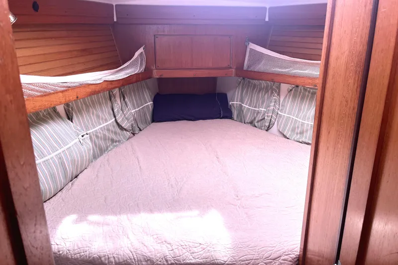 Slide: The Image of Cozy cabin interior of 2006 Catalina 400 MkII sailboat with striped pillows and wooden finish. - 42