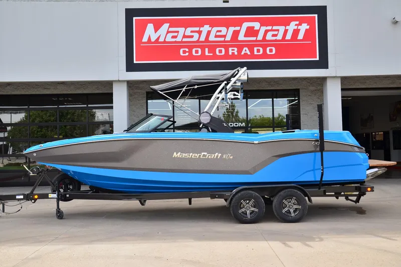 The Image of 2022 MasterCraft NXT24 boat in blue, displayed at MasterCraft Colorado dealership. - 1