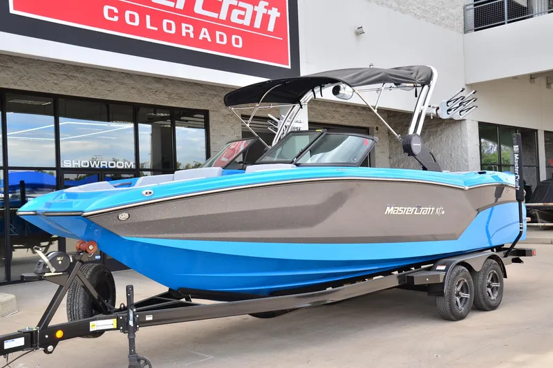 Slide: The Image of 2022 MasterCraft NXT24 boat in blue and gray, displayed at a Colorado showroom. - 6