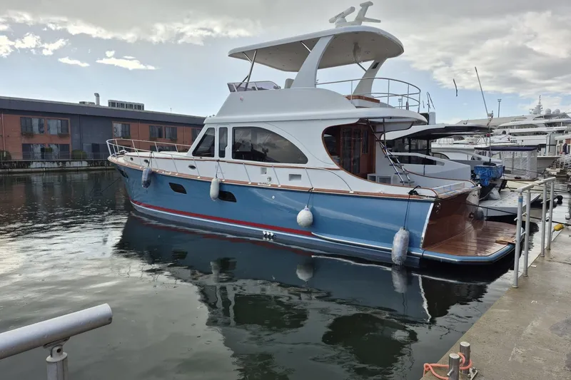 The Image of 2027 Vicem 62 Flybridge yacht docked in a marina, showcasing elegant design and blue hull. - 0