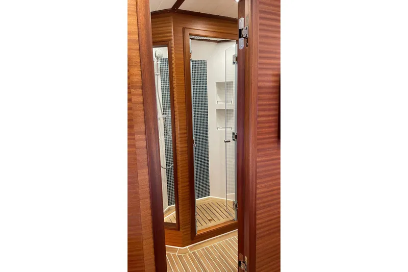 Slide: The Image of Luxurious shower area on 2027 Vicem 62 Flybridge yacht with wooden accents. - 11