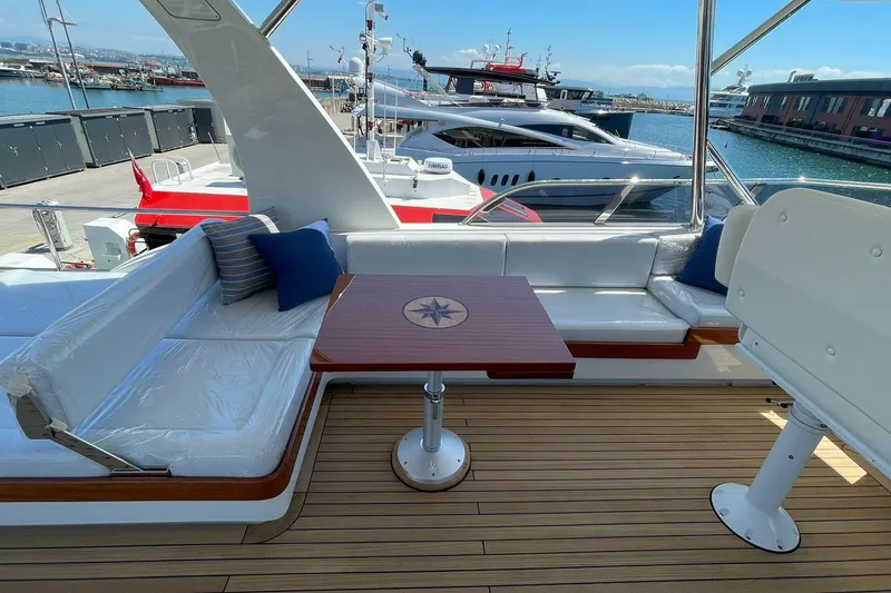 Slide: The Image of Luxurious Vicem 62 Flybridge 2027 yacht deck with elegant seating and nautical-themed table. - 4