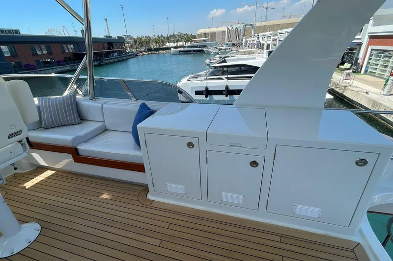 Slide: The Image of Luxurious Vicem 62 Flybridge yacht deck with seating and storage, docked at a marina. - 6