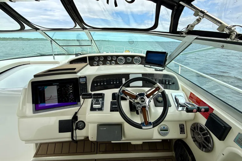 Slide: The Image of Cockpit of 1995 Sea Ray Sundancer 370 with modern navigation equipment and steering wheel. - 10