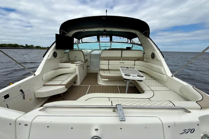 Slide: The Image of 1995 Sea Ray Sundancer 370 boat interior with seating and table on open water. - 2