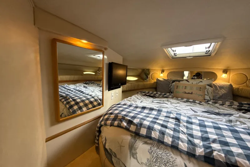 Slide: The Image of Cozy cabin interior of 1995 Sea Ray Sundancer 370 with bed, mirror, and skylight. - 30