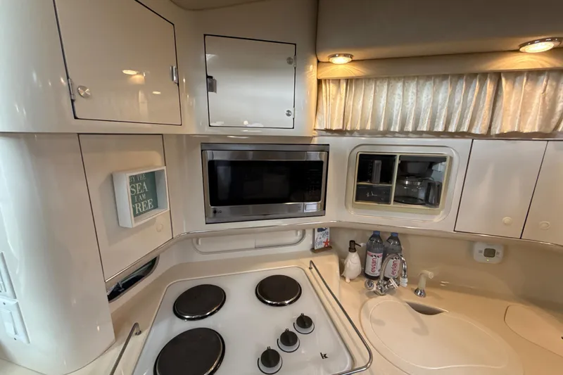 Slide: The Image of 1995 Sea Ray Sundancer 370 kitchen with stove, microwave, and storage cabinets. - 36