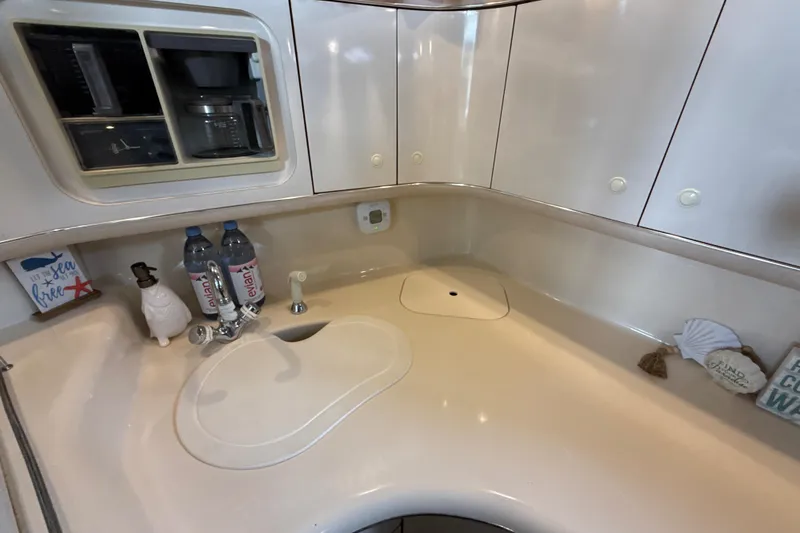 Slide: The Image of 1995 Sea Ray Sundancer 370 kitchen area with sink, cabinets, and decor items. - 38