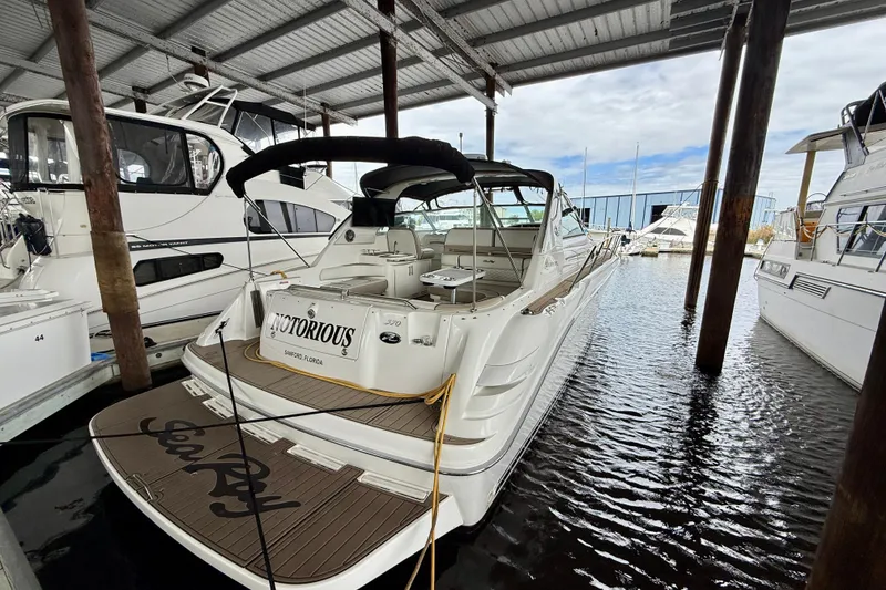 Slide: The Image of 1995 Sea Ray Sundancer 370 docked in a marina, featuring sleek design and spacious deck. - 43