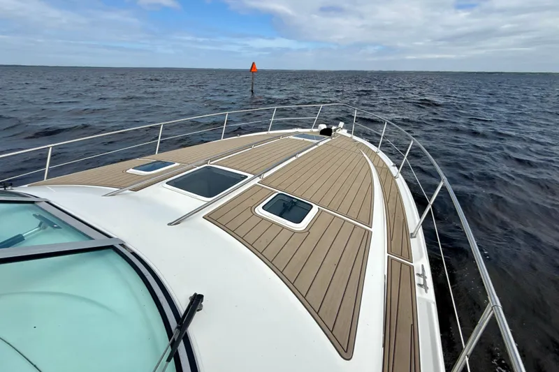 Slide: The Image of 1995 Sea Ray Sundancer 370 yacht cruising on open water under cloudy skies. - 45