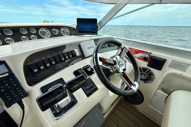 Slide: The Image of 1995 Sea Ray Sundancer 370 helm with steering wheel, gauges, and ocean view. - 47