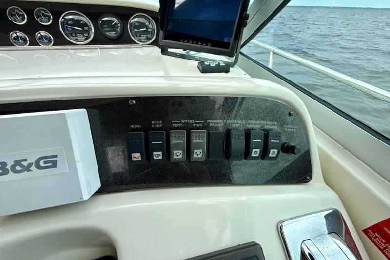 Slide: The Image of Control panel of a 1995 Sea Ray Sundancer 370 boat with switches and gauges. - 49