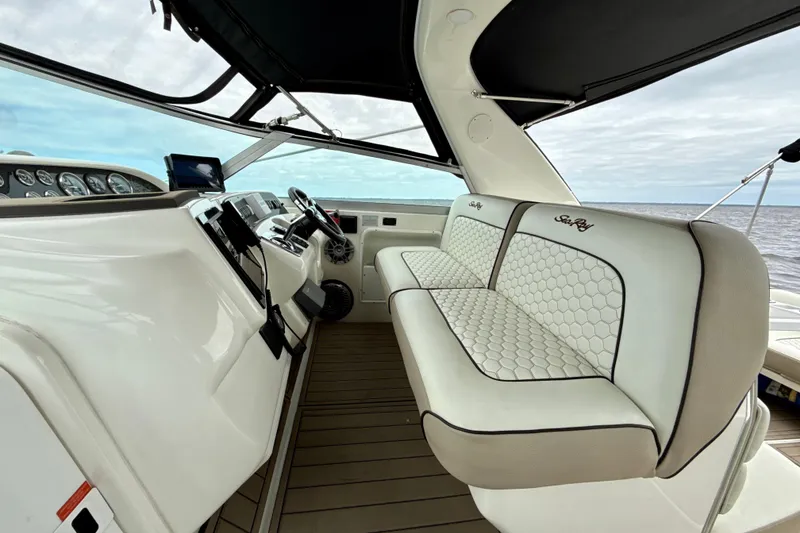 Slide: The Image of 1995 Sea Ray Sundancer 370 cockpit with luxurious seating and modern dashboard on open water. - 7