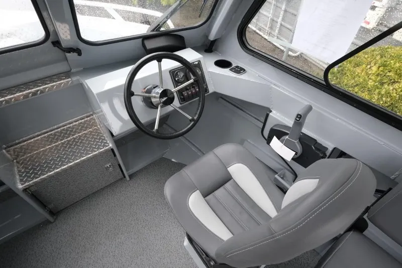 Slide: The Image of Interior of 2026 Hewescraft 200 ProV boat, featuring steering wheel and captain's chair. - 12