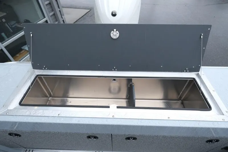 Slide: The Image of Open storage compartment on 2026 Hewescraft 200 ProV boat, featuring a sleek stainless steel interior. - 17