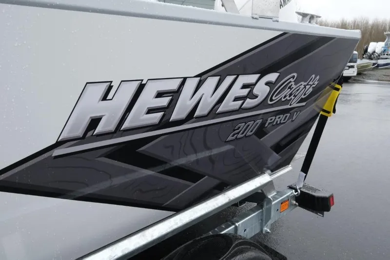 Slide: The Image of 2026 Hewescraft 200 ProV boat on trailer, showcasing sleek design and branding. - 6