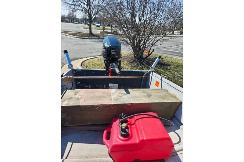 The Image of 1986 Grumman Car Topper 14 boat with motor and red fuel tank. - 1