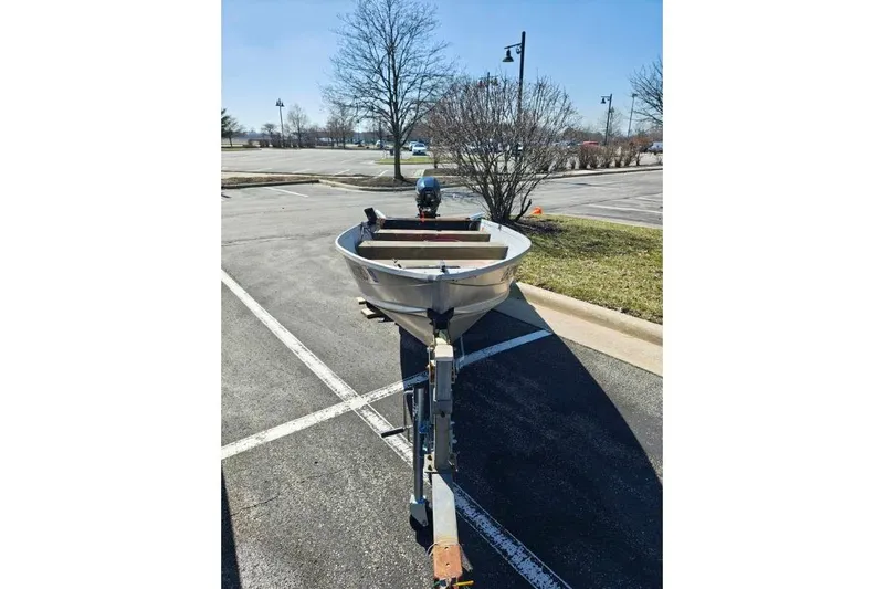 Slide: The Image of 1986 Grumman Car Topper 14 boat on trailer in parking lot. - 3