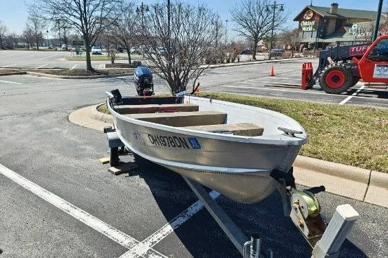 Slide: The Image of 1986 Grumman Car Topper 14 boat on trailer in parking lot. - 4