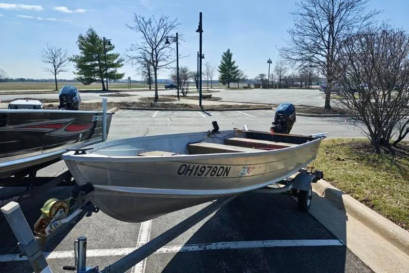 Slide: The Image of 1986 Grumman Car Topper 14 boat on trailer in parking lot. - 5