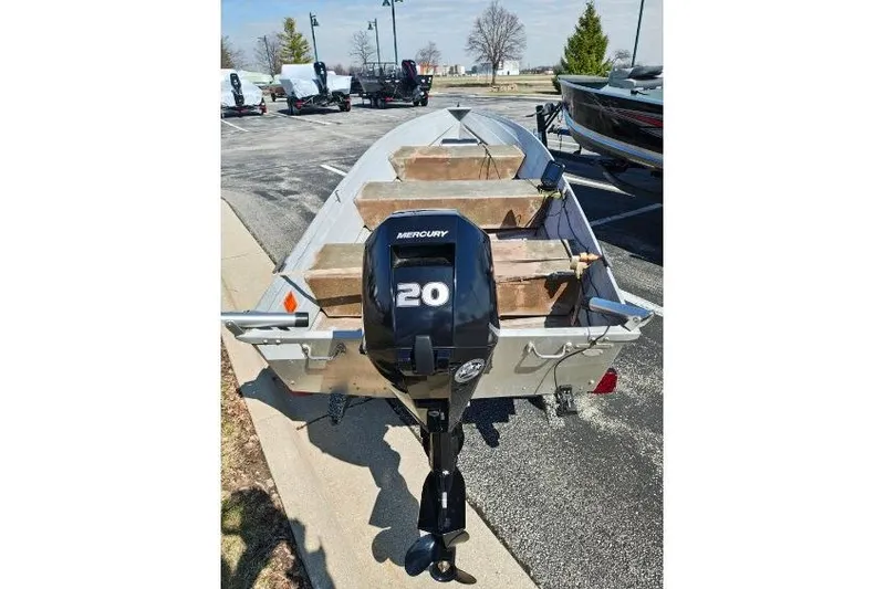 Slide: The Image of 1986 Grumman Car Topper 14 boat with Mercury 20 outboard motor in parking lot. - 6