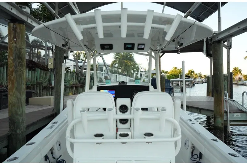 Slide: The Image of 2018 Regulator 28 boat interior with helm, docked in a marina setting. - 12