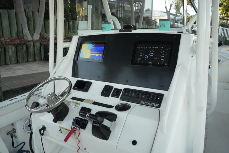 Slide: The Image of 2018 Regulator 28 boat dashboard with steering wheel and navigation screens. - 15